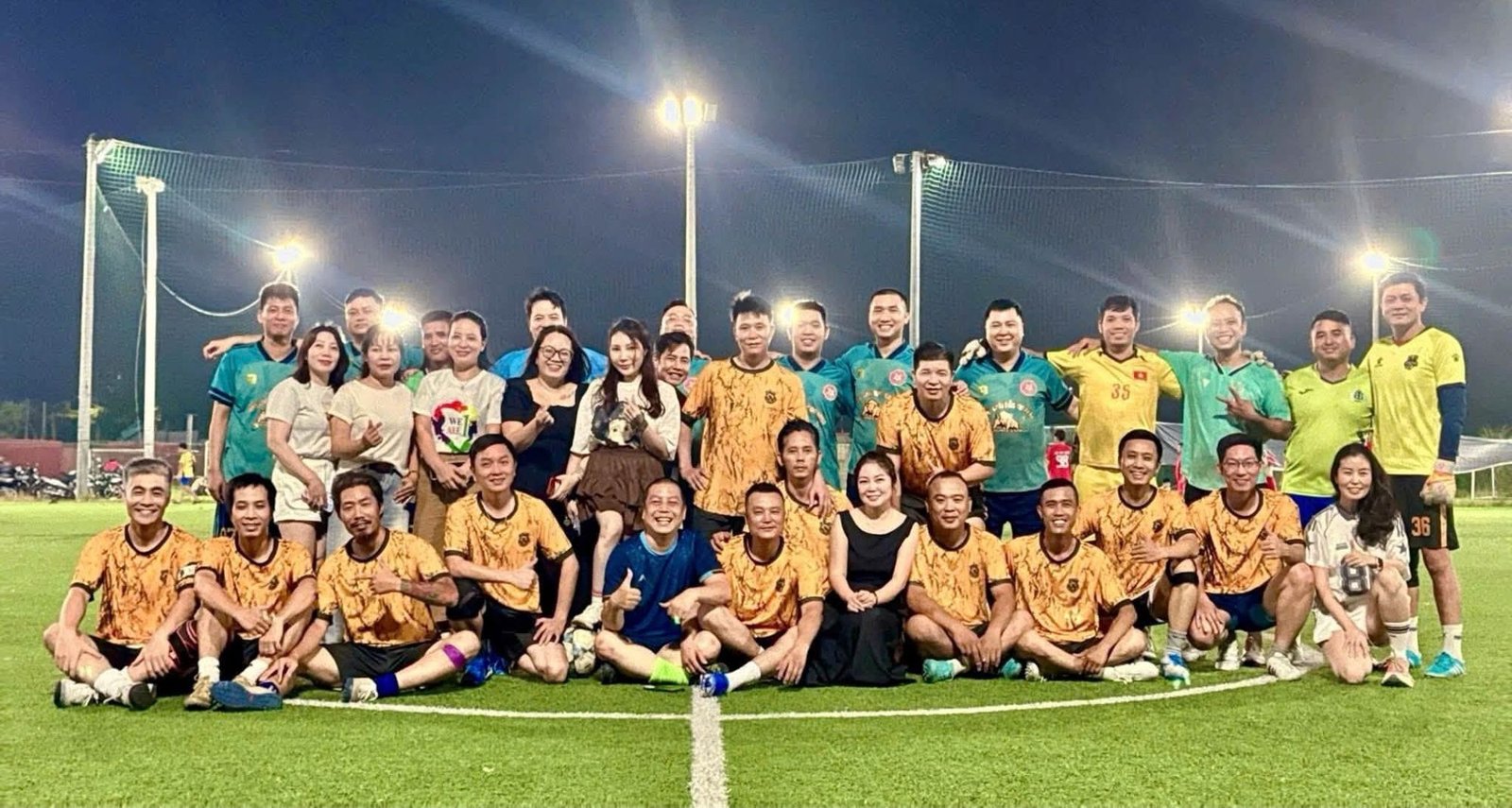 Toàn đội 1985 United FC cùng đội bạn và cổ động viên chụp ảnh tập thể dưới đèn sân buổi tối